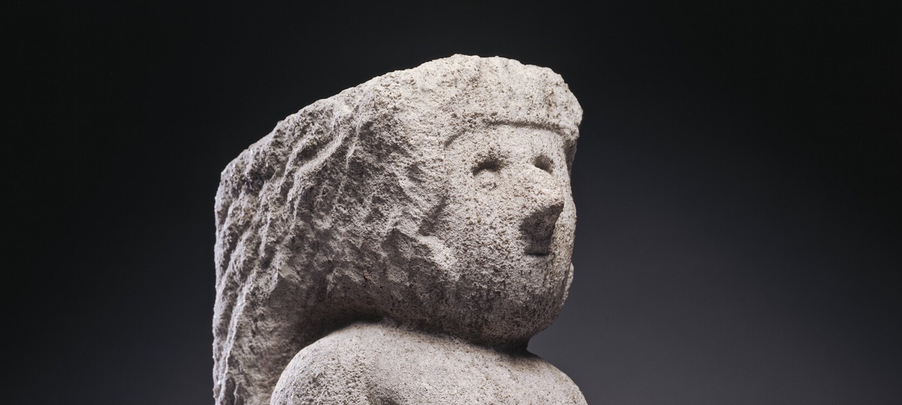 Roughly sculpted head of a person on coarse-looking white rock