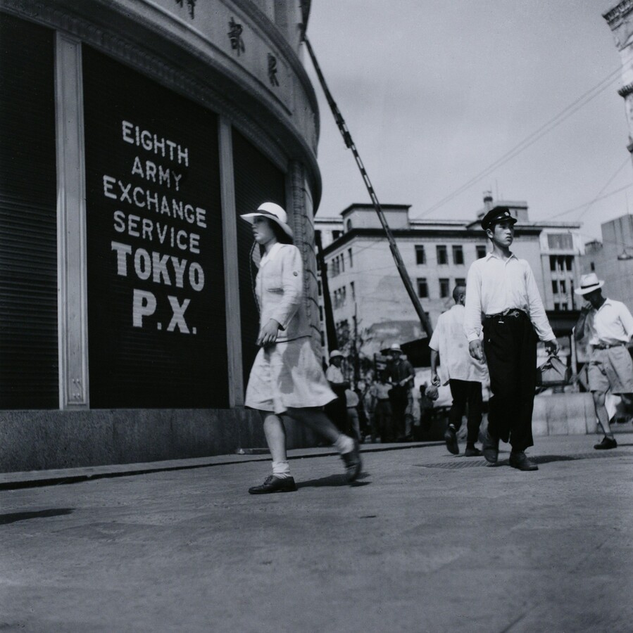 Photograph of a agricutlure workers wearing white outfits and white head coverings picking produce