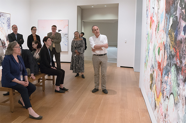 A National Gallery of Art tour guide showing a group of visitors a work of art in the East Building galleries.