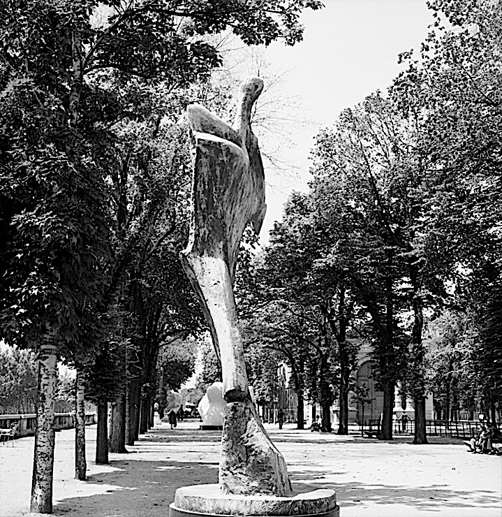 Black-and-white photograph of a Henry Moore sculpture, “Standing Figure: Knife Edge,” in the Jardin des Tuileries, Paris