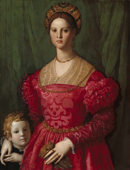A woman wearing a crimson brocade dress and gold jewelry fills most of this vertical portrait, but her right hand, on our left, rests on the shoulder of a young boy tucked into the lower left corner of the panel. The woman and boy both have pale white skin, and both face and look out at us against an emerald green curtain that falls behind them. The woman has brown eyes, a straight nose, full pink lips, smooth skin, and a long neck. Her brown hair is pulled back under a turban heavily embroidered with gold. The woman’s dress has puffed shoulders and decorative slashes on the sleeves. One gold chain rests on her throat and the other falls over her chest. She wears long gold earrings, a gold belt, and two gold rings. She holds a brown leather glove in her left hand. The boy’s face is even with the woman’s waist, and he raises his left hand to hold hers, draped over his shoulder. He has curly blond hair and dark eyes, and he wears black with a ruffled white shirt just visible at his collar.